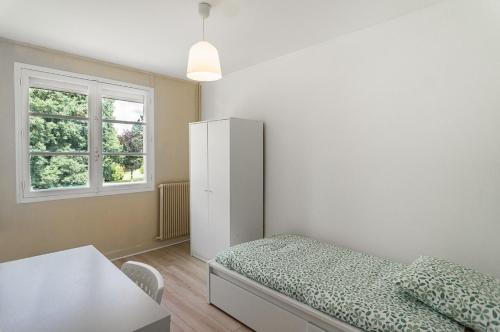 une chambre avec un lit, un bureau et une fenêtre dans l'établissement Maison meublé avec jardin, à Talence