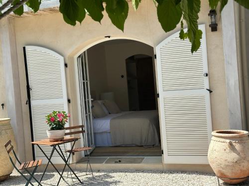 a bedroom with a bed and a table and a chair at Le Clos des Sept Palmiers in Cavalaire-sur-Mer