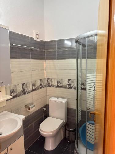 a bathroom with a toilet and a glass shower at Apartments Rudi in Orikum