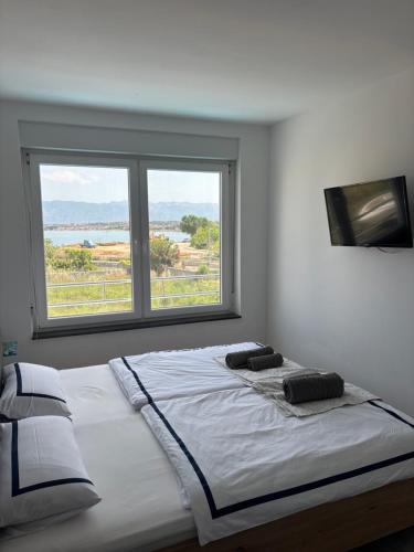 a large bed in a room with a large window at Vila Lana in Nin