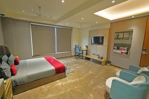 a bedroom with a bed and a couch and a table at KRYC Luxury Living near Indraprastha Apollo Hospital in New Delhi