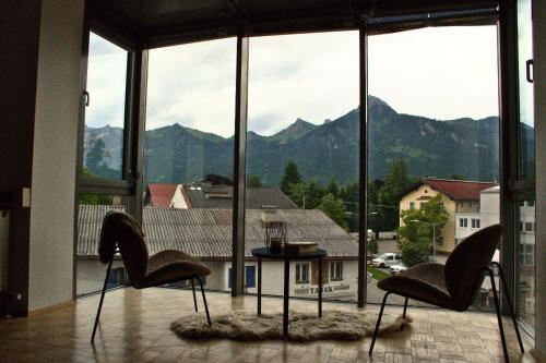 a room with two chairs and a view of mountains at Central Loft in Reutte