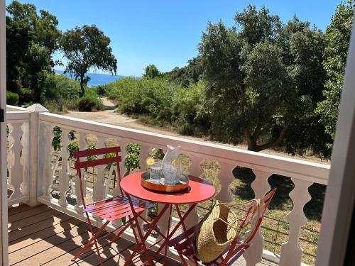 a table and two chairs on a balcony at Le Clos des Sept Palmiers in Cavalaire-sur-Mer