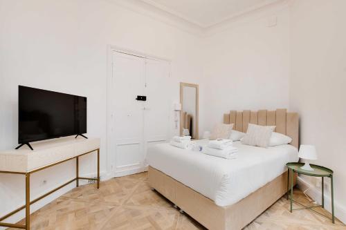 une chambre avec un lit et une télévision à écran plat dans l'établissement Elegant studio - 2P - Auteuil Bois de Boulogne, à Paris