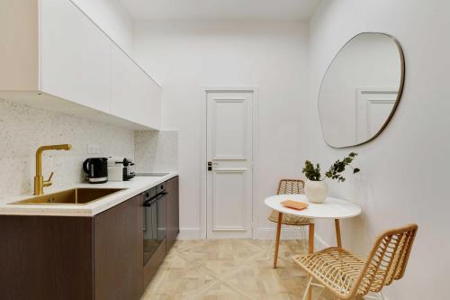 - une cuisine avec un évier, une table et un miroir dans l'établissement Elegant studio - 2P - Auteuil Bois de Boulogne, à Paris