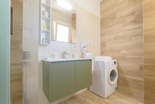 a bathroom with a washing machine and a sink at Arivincè in Conversano