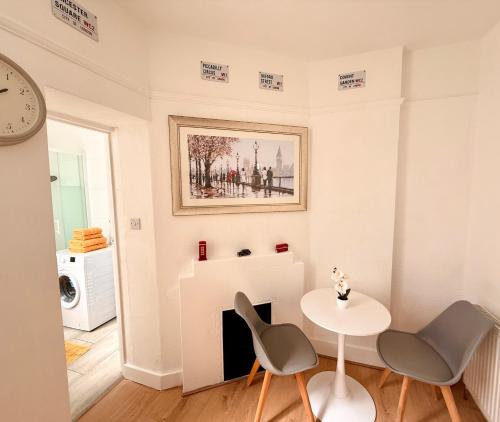 a living room with a table and chairs and a fireplace at Candy Cafe Apartment in London