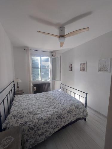 une chambre avec un lit et une fenêtre dans l'établissement La quiétude de St Antoine - piscine privée, à LʼIsle-sur-la-Sorgue