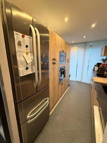 une cuisine avec un réfrigérateur en acier inoxydable et des armoires en bois dans l'établissement Chez Geremio - T4 - Centre Ville, à Annecy