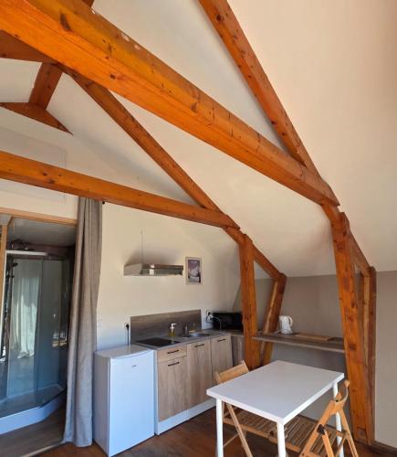 - une cuisine avec une table blanche dans une pièce dans l'établissement Chalet avec piscine 2C, à Laffrey