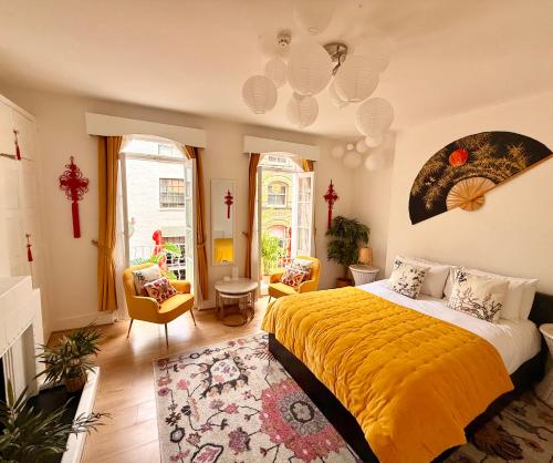 a bedroom with a large bed with a yellow blanket at Candy Cafe Apartment in London