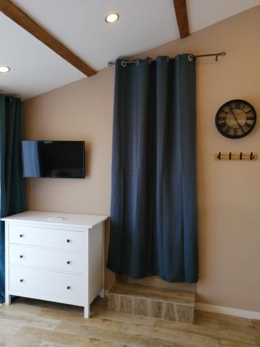 - une chambre avec un rideau noir et une commode dans l'établissement Charmant logement 2 personnes avec extérieur, à Orange