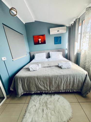 a bedroom with a bed with a blue wall at Rajs Apartment in Tirana