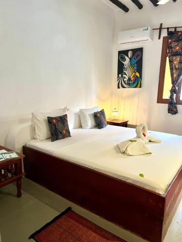 a bedroom with a bed with a stuffed animal on it at The African Paradise Beach Hotel in Bwejuu