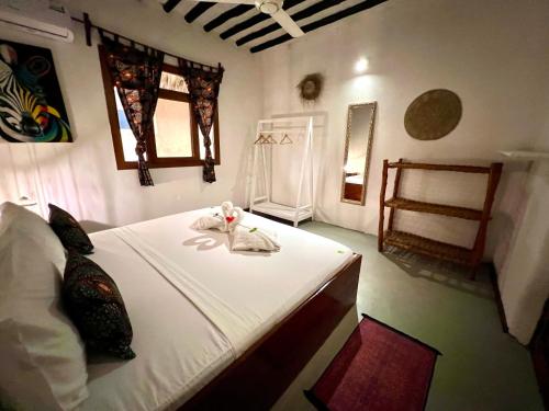 a bedroom with a bed with a towel on it at The African Paradise Beach Hotel in Bwejuu