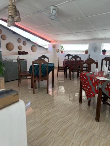 jadalnia z drewnianymi krzesłami i stołami oraz tablesearcherem w obiekcie Vivi Cafe B&B w mieście Zanzibar