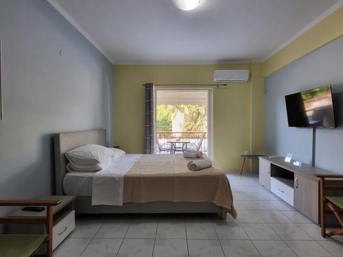 a bedroom with a bed and a television and a window at GM Apartments in Tolo
