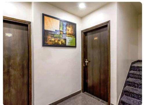 a hallway with two doors and a picture on the wall at Near Railway Station Hotel Imperial in Ajmer