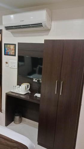 a room with a tv and a brown cabinet at Near Railway Station Hotel Imperial in Ajmer