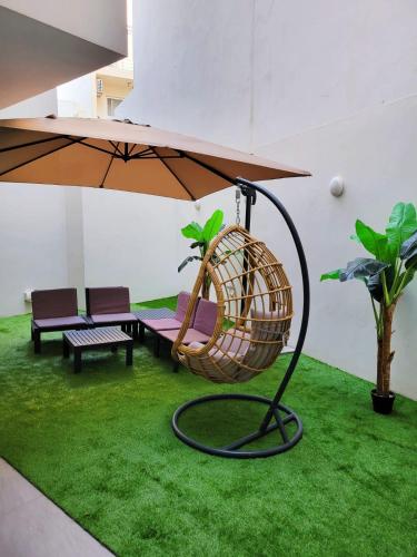a wicker chair and an umbrella in a room at Luxury brand new holiday apartments TOP location in Is-Swieqi