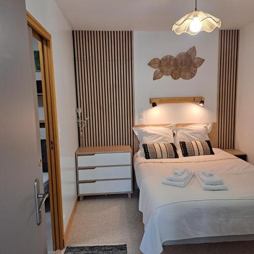 une chambre avec un lit avec deux serviettes dessus dans l'établissement Ty Colibri Lannion, à Lannion