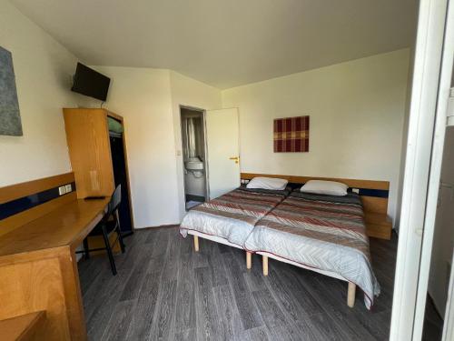 Saint-Jean-le-PricheにあるHotel Charme En Maconnais Fasthotel Macon Nordのベッドと机が置かれた寝室