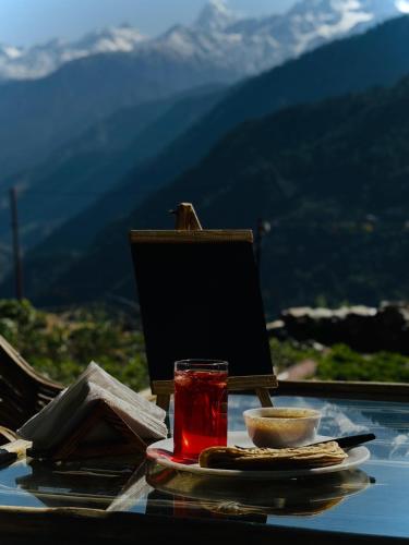 a table with a drink and a plate of food at Gaonvasi Homestay in Uttarkāshi