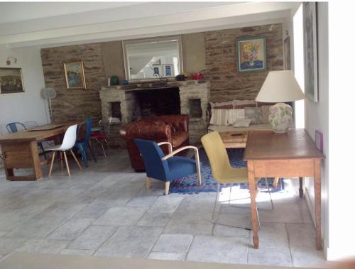 - un salon avec des chaises, une table et une cheminée dans l'établissement Maison les pieds dans l'eau - Vue exceptionnelle, à Groix