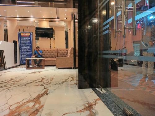 a man sitting at a table in a lobby at HOTEL BINAPANI Deluxe 1 in Tarapith