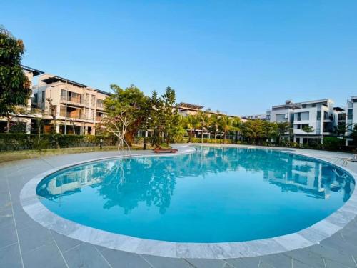 Una gran piscina azul con edificios al fondo. en Lucee 4 bedrooms apartment Phu Quoc, en Phu Quoc