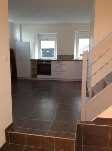 une cuisine avec des armoires blanches et un four noir dans l'établissement Appartement centre bourg, à Ploeren