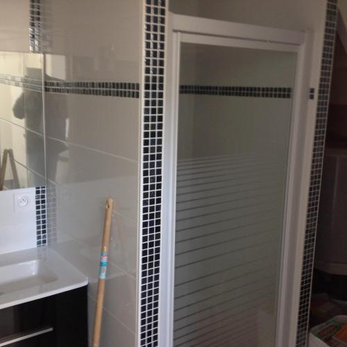 une douche avec une porte vitrée dans une salle de bain dans l'établissement Appartement centre bourg, à Ploeren