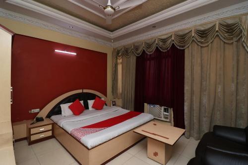 丹巴德Super Hotel O Akash Regency的酒店客房,设有一张红色墙壁的床