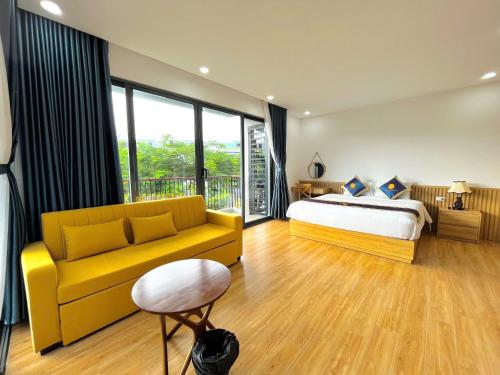 1 dormitorio con cama y sofá amarillo en Lucee 4 bedrooms apartment Phu Quoc, en Phu Quoc