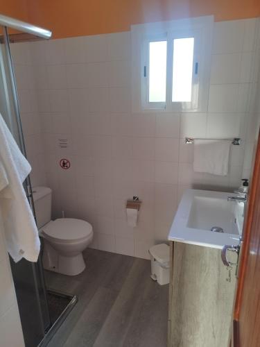 a white bathroom with a toilet and a sink at Pequeño Estudio Pinar 2 in Puntagorda