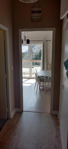 une salle à manger avec une table et une porte en verre dans l'établissement Appartement T2 avec terrasse Luchon, à Luchon