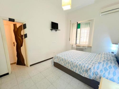 une chambre avec un lit et une télévision au mur dans l'établissement Marea, vicino mare con parcheggio by Alfareal, à Castiglione della Pescaia