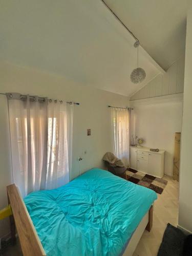 Un dormitorio con una cama con una manta azul. en Vecan, en Grisy-Suisnes