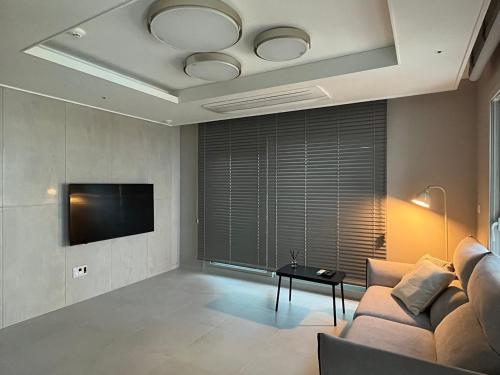 a living room with a couch and a tv at Busan Osiria Residence Losiria in Busan