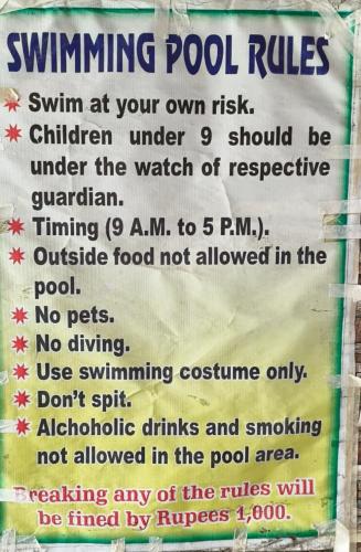a sign that reads swimming pool rulesirm at your own risk children under at Hotel Inn New Digha With Classic Swimming Pool in Digha