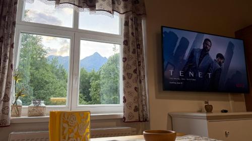 a living room with a tv and a window at Mountain Peak Apartment in Tatranská Lomnica