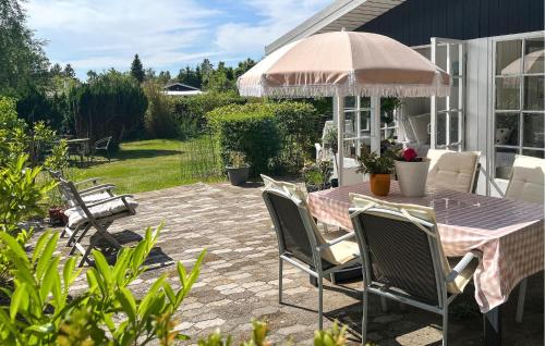 a patio with a table and chairs and an umbrella at 3 Bedroom Stunning Home In Eskebjerg in Eskebjerg