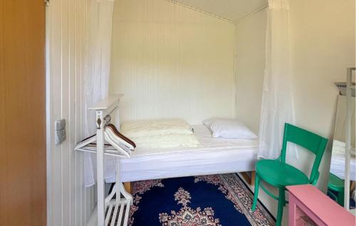 a small bedroom with a bed and a green chair at 3 Bedroom Stunning Home In Eskebjerg in Eskebjerg