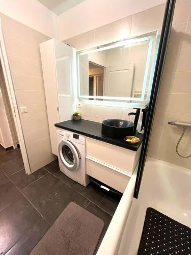 La petite salle de bains est pourvue d'un lavabo et d'un lave-linge. dans l'établissement Grand jardin - Climatisation - parking privatif, à Nîmes