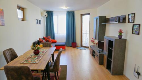 a living room with a dining room table and a television at Byala Vista Beach Apartments D - Бяла Виста Бийч Апартментс Д in Byala