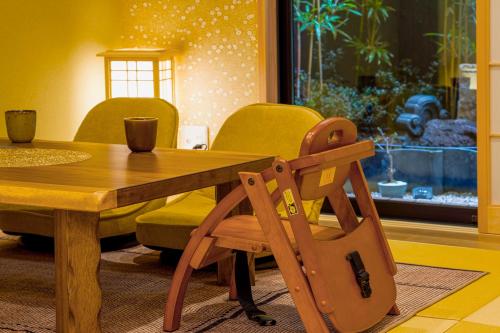a dining room with a wooden table and chairs at Kyoki Machiya near Kyoto Station Exquisite Garden in Kyoto