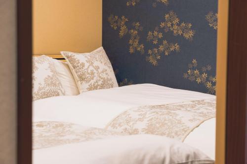 a bedroom with two beds with white sheets and pillows at Kyoki Machiya near Kyoto Station Exquisite Garden in Kyoto