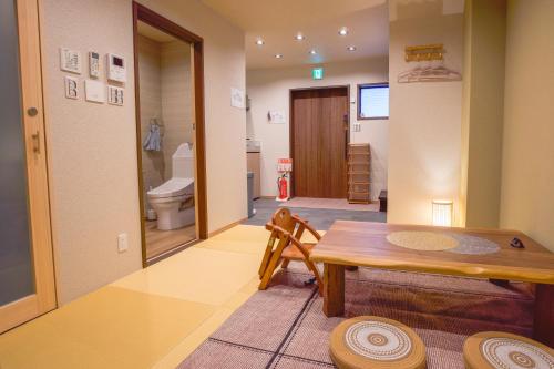 a room with a table and a bathroom with a toilet at Kyoki Machiya near Kyoto Station Exquisite Garden in Kyoto