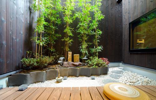 a garden with bamboo trees and a wooden deck at Kyoki Machiya near Kyoto Station Exquisite Garden in Kyoto