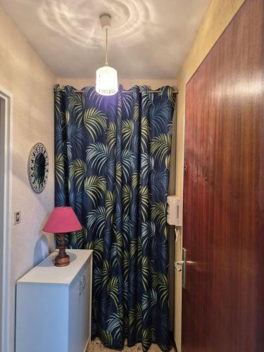un rideau dans une pièce avec une porte et une lampe dans l'établissement Appartement studio Fabregas vue mer, à La Seyne-sur-Mer